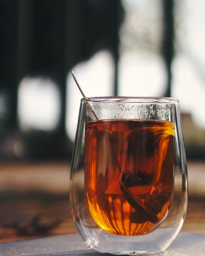 Brown wooden table with some brown liquid, drinking cup
